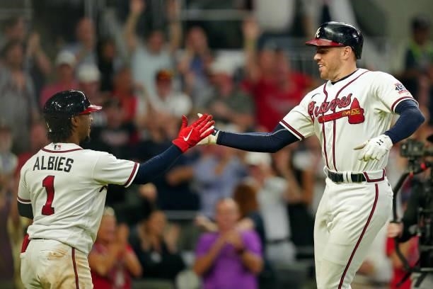 Freddie Freeman of the Atlanta Braves celebrates with Ozzie Albies after hitting a solo home run in the bottom the eighth inning during Game 4 of the...