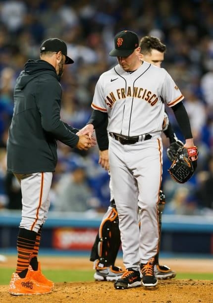 Anthony DeSclafani of the San Francisco Giants hands the ball to Gabe Kapler of the San Francisco Giants in the second inning during Game 4 of the...