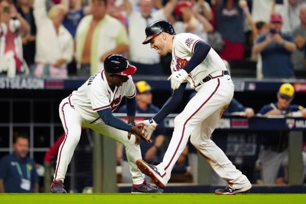 Freddie Freeman of the Atlanta Braves celebrates with Third Base Coach Ron Washington after hitting a solo home run in the bottom the eighth inning...