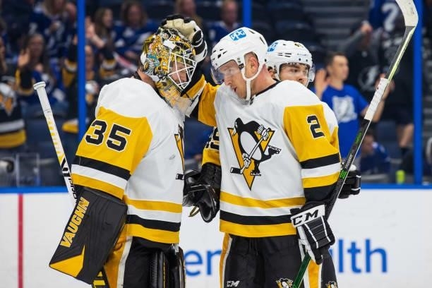 Goalie Tristan Jarry and Chad Ruhwedel of the Pittsburgh Penguins celebrate the win against the Tampa Bay Lightning at Amalie Arena on October 12,...