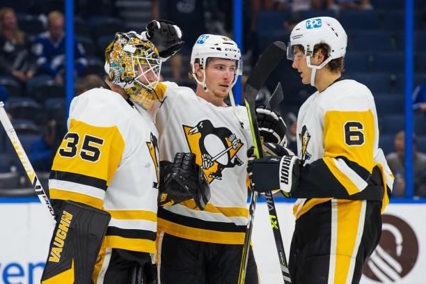Goalie Tristan Jarry, Brock McGinn, and John Marino of the Pittsburgh Penguins celebrate the win against the Tampa Bay Lightning at Amalie Arena on...