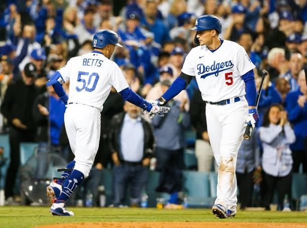 Mookie Betts of the Los Angeles Dodgers hi fives Corey Seager of the Los Angeles Dodgers after hitting a two run home run in the fourth inning during...