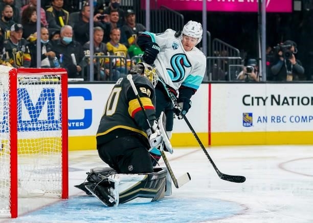 Ryan Donato of the Seattle Kraken keeps an eye on the puck as goaltender Robin Lehner of the Vegas Golden Knights reacts to a shot during first...