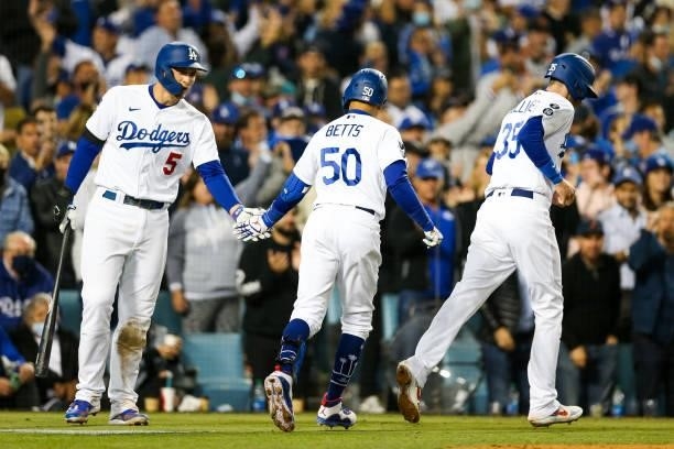 Mookie Betts of the Los Angeles Dodgers hi fives Corey Seager of the Los Angeles Dodgers after hitting an RBI sac fly in the fifth during Game 4 of...