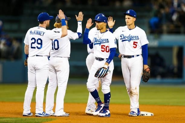 Mookie Betts and Corey Seager hi five Justin Turner and Billy McKinney of the Los Angeles Dodgers after the final out of Game 4 of the NLDS between...
