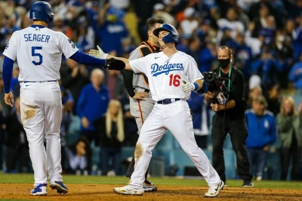 Will Smith hi fives Corey Seager of the Los Angeles Dodgers after hitting a 2 run home run in the eighth inning during Game 4 of the NLDS between the...