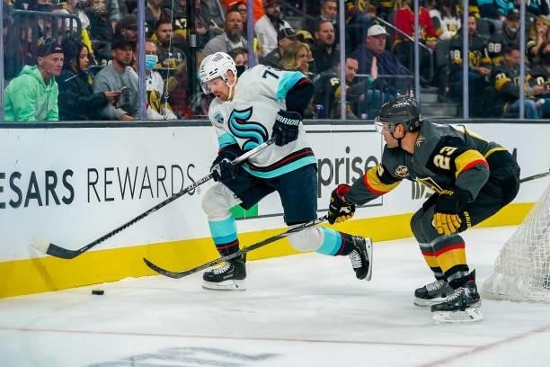 Joonas Donskoi of the Seattle Kraken plays the puck along the boards to avoid Alec Martinez of the Vegas Golden Knights during first period action at...