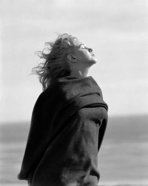 Portrait of American actress and model Marilyn Monroe as she poses, outdoors, wrapped in an army blanket, Malibu, California, 1946.