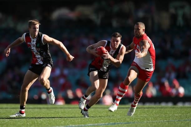 Brad Crouch of the Saints is challenged by Lance Franklin of the Swans during the round 12 AFL match between the St Kilda Saints and the Sydney Swans...