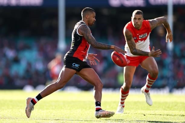 Bradley Hill of the Saints kicks infront of Lance Franklin of the Swans during the round 12 AFL match between the St Kilda Saints and the Sydney...