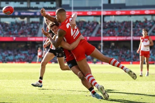 Lance Franklin of the Swans handballs whilst being tackled by Jack Steele of the Saints during the round 12 AFL match between the St Kilda Saints and...