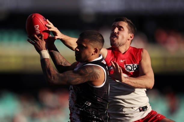 Bradley Hill of the Saints is challenged by Jake Lloyd of the Swans during the round 12 AFL match between the St Kilda Saints and the Sydney Swans at...