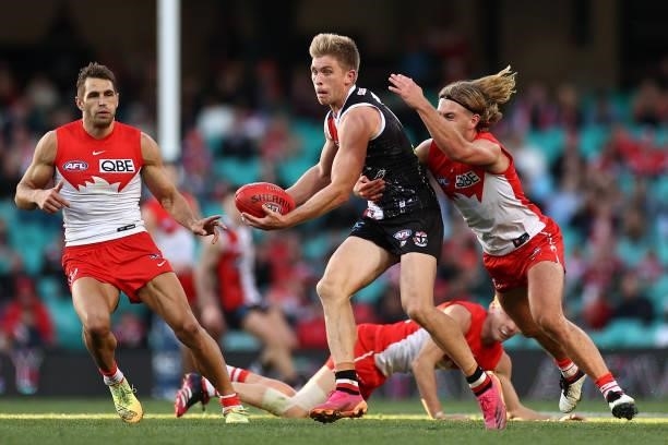 Sebastian Ross of the Saints handballs whilst being tackled during the round 12 AFL match between the St Kilda Saints and the Sydney Swans at Sydney...