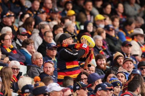 Fan throws the ball back onto the ground during the round 12 AFL match between the Adelaide Crows and the Collingwood Magpies at Adelaide Oval on...