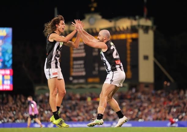 Caleb Poulter of the Magpies celebrates with Steele Sidebottom of the Magpies during the round 12 AFL match between the Adelaide Crows and the...