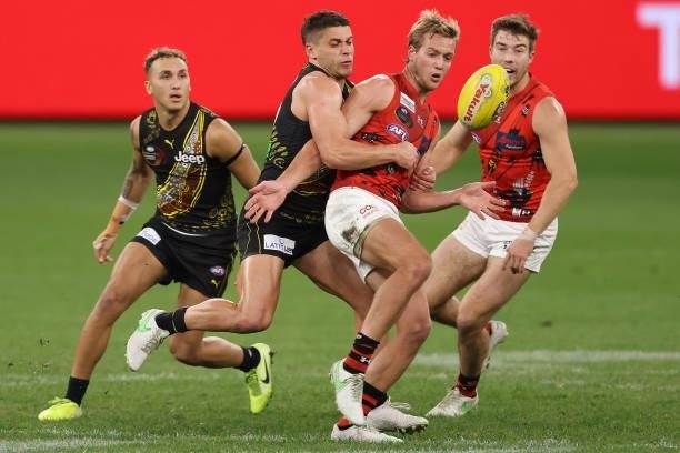 Dion Prestia of the Tigers tackles Darcy Parish of the Bombers during the round 12 AFL match between the Essendon Bombers and the Richmond Tigers at...