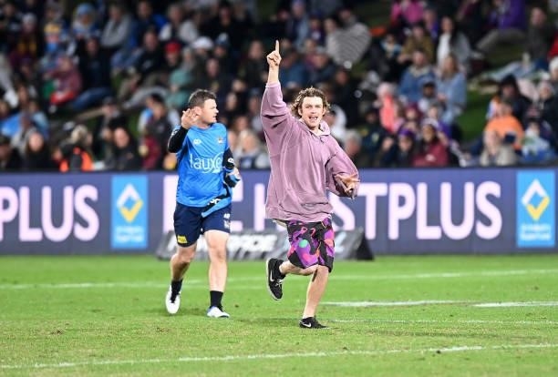 Pitch invader runs onto the ground during the round 13 NRL match between the Melbourne Storm and the Gold Coast Titans at Sunshine Coast Stadium, on...