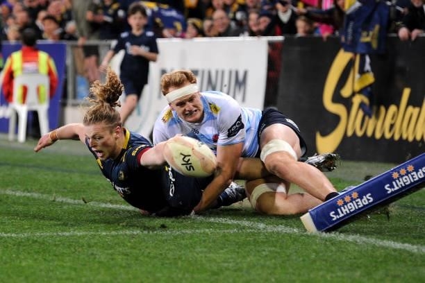 Scott Gregory of the Highlanders reaches for the try line as he is tackled into touch during the round four Super Rugby Trans-Tasman match between...