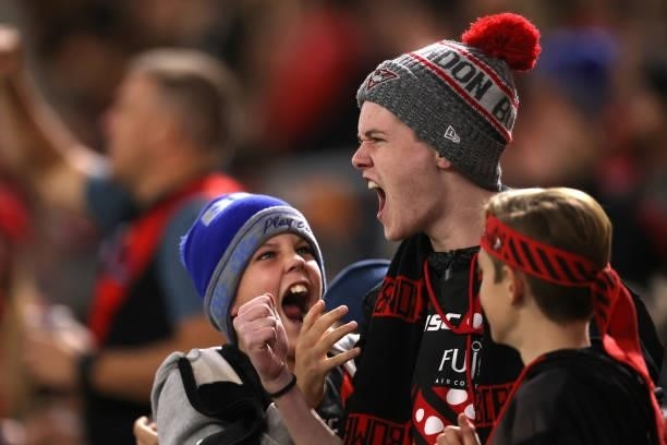 Young Bombers fans celebrate a goal during the round 12 AFL match between the Essendon Bombers and the Richmond Tigers at Optus Stadium on June 05,...