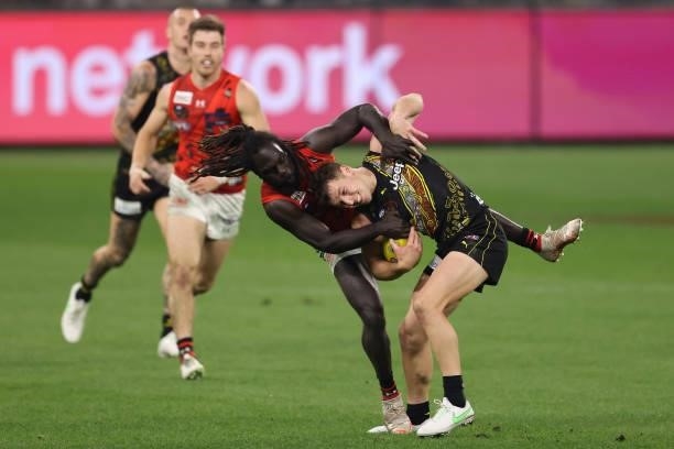 Jake Aarts of the Tigers gets tackles by Anthony McDonald-Tipungwuti of the Bombers during the round 12 AFL match between the Essendon Bombers and...