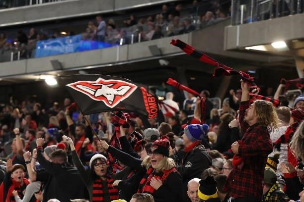 Bombers fans celebrate a goal during the round 12 AFL match between the Essendon Bombers and the Richmond Tigers at Optus Stadium on June 05, 2021 in...