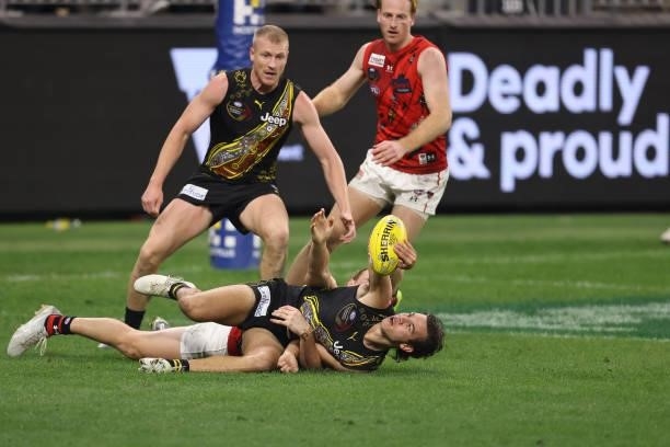 Daniel Rioli of the Tigers gets tackles Mason Redman of the Bombers during the round 12 AFL match between the Essendon Bombers and the Richmond...