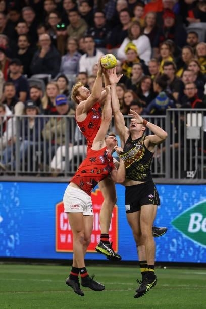 Andrew Phillips of the Bombers contest for a mark during the round 12 AFL match between the Essendon Bombers and the Richmond Tigers at Optus Stadium...