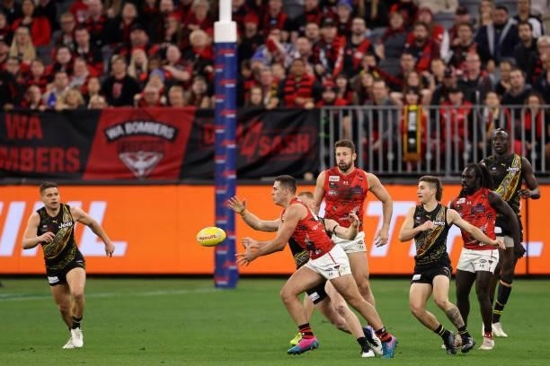 Alec Waterman of the Bombers handballs during the round 12 AFL match between the Essendon Bombers and the Richmond Tigers at Optus Stadium on June...