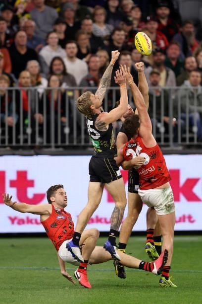Nathan Broad of the Tigers looks to spoil the mark for Cale Hooker of the Bombers during the round 12 AFL match between the Essendon Bombers and the...