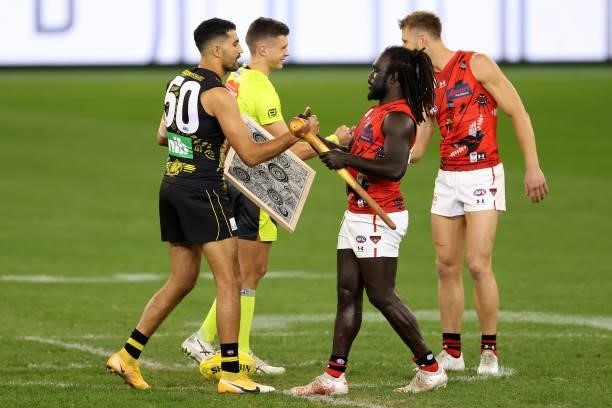 Marlion Pickett of the Tigers and Anthony McDonald-Tipungwuti of the Bombers exchange gifts before the coin toss during the round 12 AFL match...
