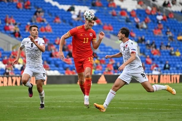 Kieffer Moore of Wales heads the ball towards goal and misses whilst being chased down by Berat Djimsiti and Marash Kumbulla of Albania during the...