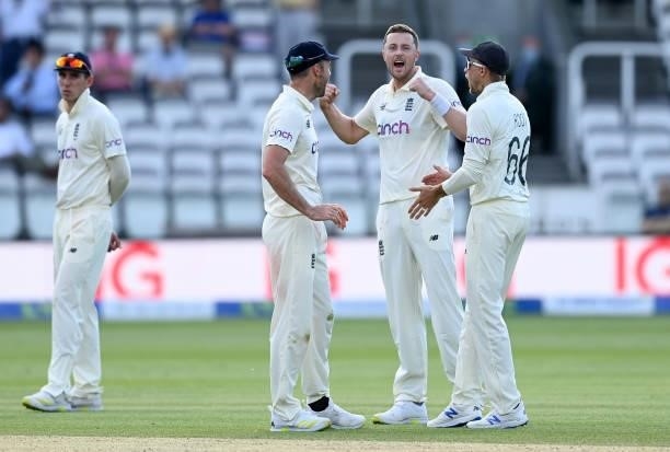 Ollie Robinson of England celebrates the successful review and dismissal of Kane Williamson of New Zealand with James Anderson and Joe Root during...
