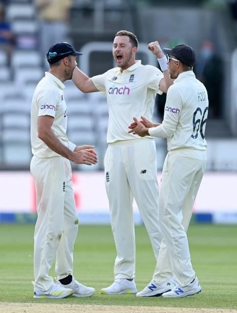 Ollie Robinson of England celebrates the successful review and dismissal of Kane Williamson of New Zealand with James Anderson and Joe Root during...