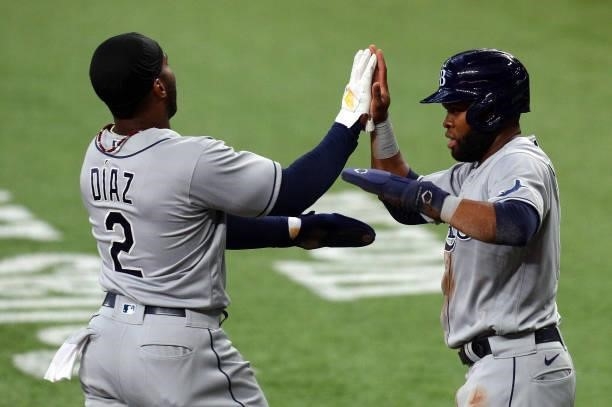 Yandy Diaz of the Tampa Bay Rays is greeted at the plate by Manuel Margot after they scored on a hit by Austin MEadows in the first inning against...