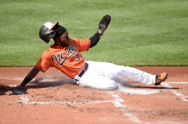 Cedric Mullins of the Baltimore Orioles slides into home plate and scores in the first inning against the Cleveland Indians at Oriole Park at Camden...
