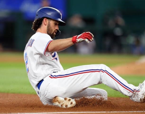 Charlie Culberson of the Texas Rangers slides into third on a triple in the fifth inning against the Tampa Bay Rays at Globe Life Field on June 05,...