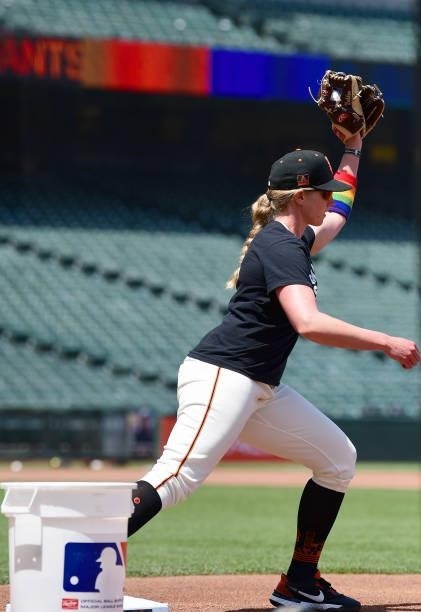 Coach Alyssa Nakken of the San Francisco Giants takes throws at first base wearing wrist bands on her forearm with rainbow colors that symbolize the...
