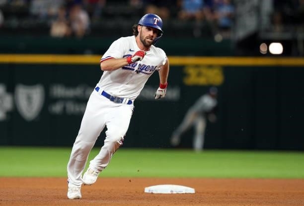Charlie Culberson of the Texas Rangers rounds second after hitting for a triple in the fifth inning against the Tampa Bay Rays at Globe Life Field on...