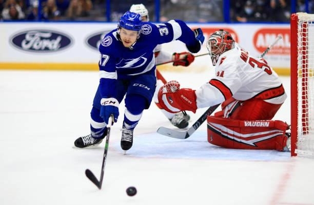 Yanni Gourde of the Tampa Bay Lightning stretches for the puck during Game Four of the Second Round of the 2021 Stanley Cup Playoffs against the...