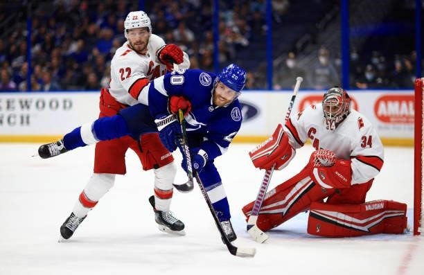 Blake Coleman of the Tampa Bay Lightning and Brett Pesce of the Carolina Hurricanes fights for position during Game Four of the Second Round of the...