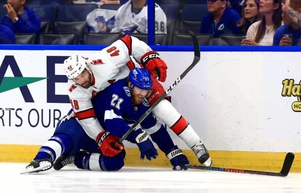Jordan Martinook of the Carolina Hurricanes and Brayden Point of the Tampa Bay Lightning collide during Game Four of the Second Round of the 2021...