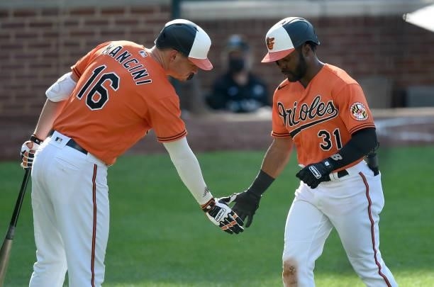 Cedric Mullins of the Baltimore Orioles celebrates with Trey Mancini after hitting a home run in the third inning against the Cleveland Indians at...