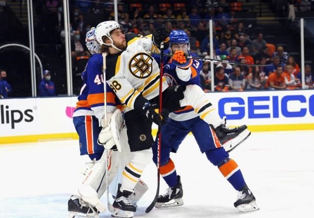 Semyon Varlamov and Adam Pelech of the New York Islanders defend against David Pastrnak of the Boston Bruins during the first period in Game Four of...