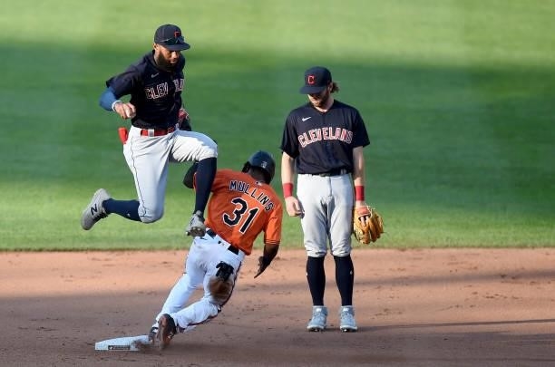 Amed Rosario of the Cleveland Indians jumps over Cedric Mullins of the Baltimore Orioles after forcing him out at second base in the seventh inning...