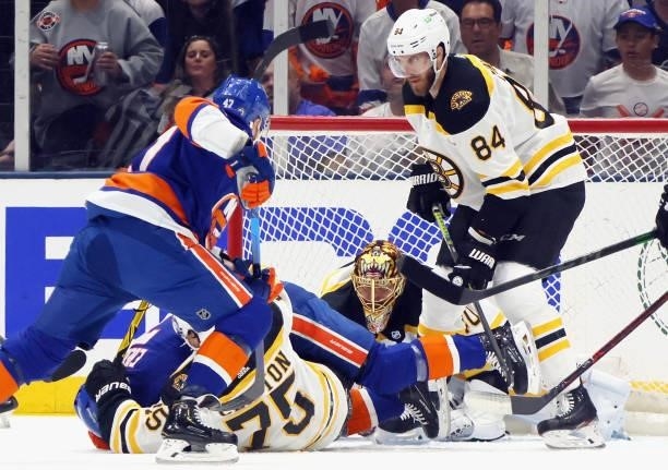 Connor Clifton, Tuukka Rask and Jarred Tinordi of the Boston Bruins defend the net against the New York Islanders during the first period in Game...