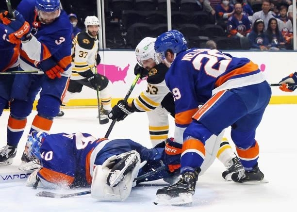Semyon Varlamov of the New York Islanders covers the puck during the first period against Brad Marchand of the Boston Bruins in Game Four of the...