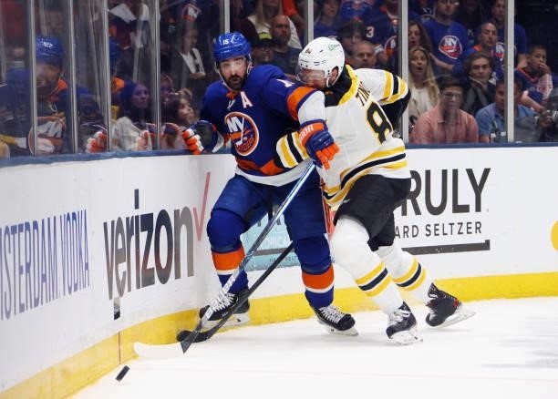 Jarred Tinordi of the Boston Bruins slows down Cal Clutterbuck of the New York Islanders during the second period in Game Four of the Second Round of...