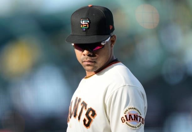LaMonte Wade Jr of the San Francisco Giants looks on while wearing a cap with the Giants logo dressed with rainbow colors that symbolize the LGBTQ...