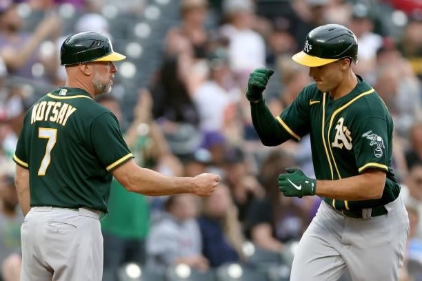 Matt Olson of the Oakland Athletics is congratulated by third base coach Mark Kotsay as he circles the bases after hitting a 2 RBI home run against...