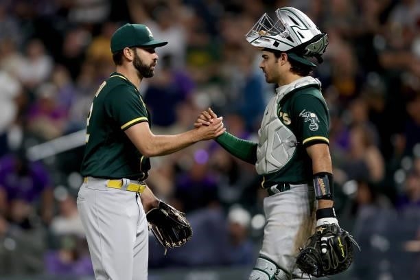 Pitcher Lou Trivino and catcher Aramis Garcia of the Oakland Athletics celebrate their win against the Colorado Rockies after the last out in the...